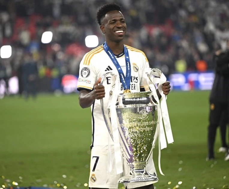 Real Madrid's Brazilian forward Vinicius Junior poses with the trophy to celebrate the victory at the end of the UEFA Champions League final football match between Borussia Dortmund and Real Madrid, at Wembley stadium, in London, on June 1, 2024.